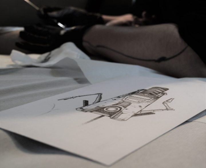 Photo d'un dessin de claptrap du jeux video borderland. Tatouage handpoke sur le bras