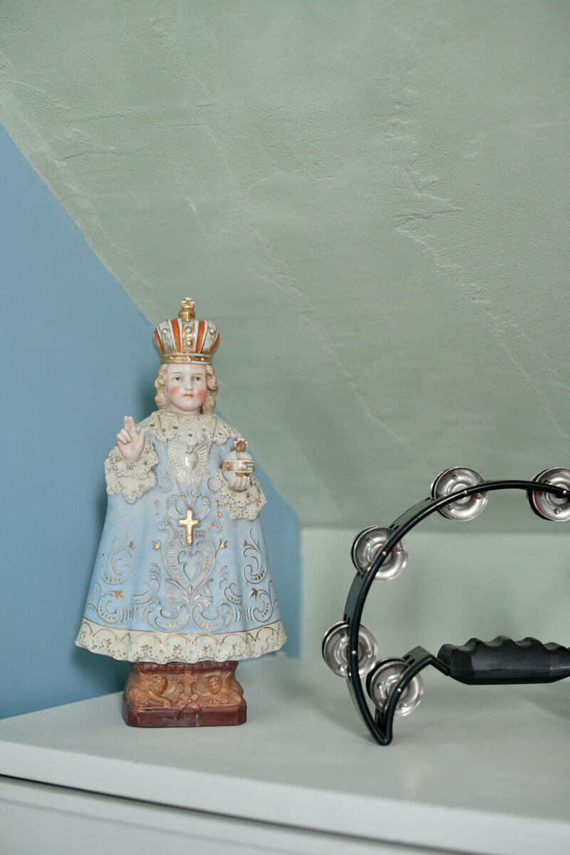 une décoration d'un salon de tatouage privé avec une statue d'un pape et un tambourin